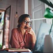 person thinking about something while sitting at a computer