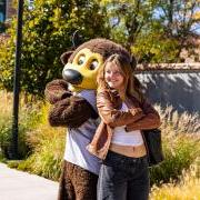 Chip the buffalo mascot poses with a new student on campus